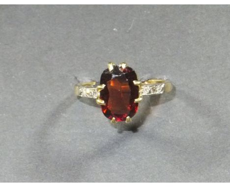 A 22 carat gold and garnet set dress ring, the single stone flanked by diamond set shoulders, Size R