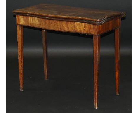 A George III mahogany serpentine fronted card table, the foldover top opening to reveal a green baize interior on square tape