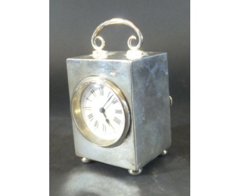 An Edwardian silver carriage clock with swing handle to top, the white enamelled dial set with Roman numerals, the French mov