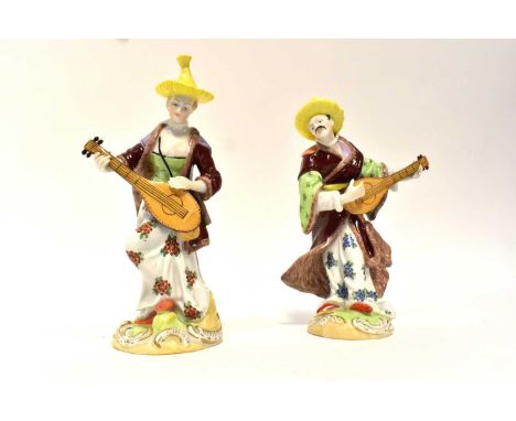 DRESDEN; a matched pair of 19th century figures of Malabar musicians, after the models by F. E. Meyer, each wearing a straw h