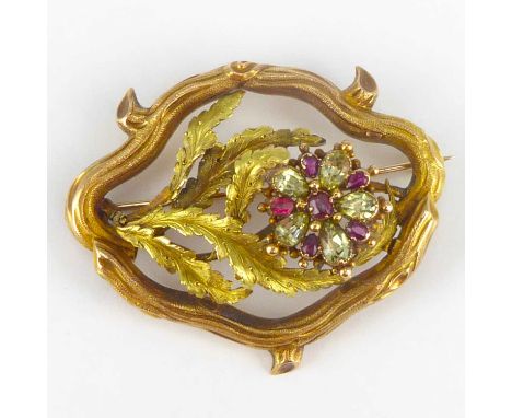A 19th century gold brooch with floral centre featuring a flower head consisting of marquise cut rubies and light green stone