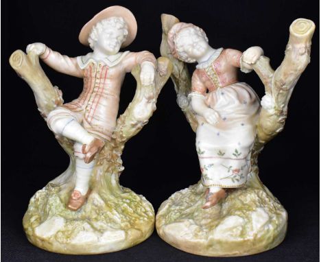 HADLEY WORCESTER; two c.1890 Royal Worcester figures modelled as children seated in branches, in blush ivory tones, model num
