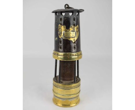 An early 20th century miners' lamp with wire mesh centre, five outer columns, steel funnel and brass base, partial brass pit 