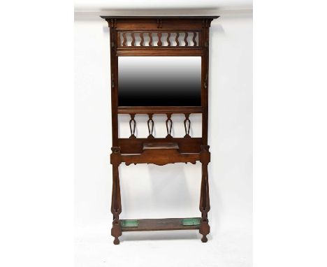 An early 20th century mahogany hall stand with bevelled mirror above lift-up compartments, flanked by stick stands with drip 