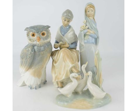 Four Spanish porcelain figures, to include a Lladró girl with lilies, height 23cm, a Nao owl, height 17.5cm, a Nao gaggle of 