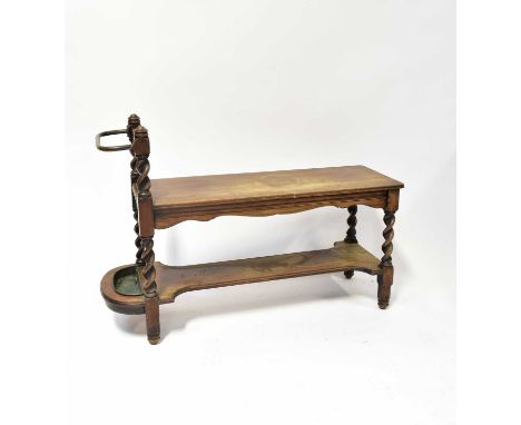 An early 20th century oak hall bench or table with undershelf, twist side supports and side stick stand with drip tray, 74 x 