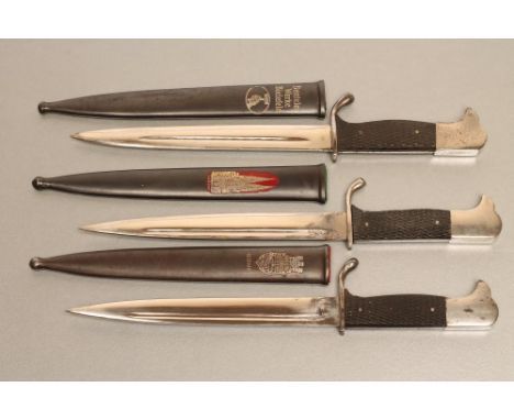 THREE GERMAN MINIATURE BAYONETS,1918-45, two with metal scabbards bearing souvenir medallions for the city of Bonn and Cologn