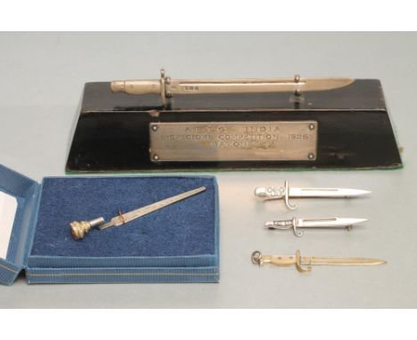 FOUR SILVER MINIATURE BAYONETS, including a trophy modelled on the m.1907 British bayonet marked for London 1926, on a wooden