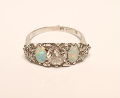 A DIAMOND AND OPAL RING, the central brilliant cut stone of approximately 1.10cts, claw set and flanked by two oval cabochon 