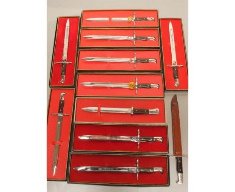 TEN JAPANESE MADE MINIATURE BAYONETS FOR THE US MARKET, seven with applied military badges, seven with blade inscriptions and