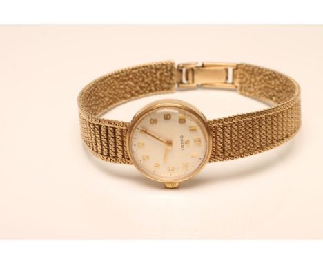 A LADY'S 9CT GOLD OMEGA WRISTWATCH, the pale champagne dial with applied gilt metal Arabic numerals, seventeen jewel movement