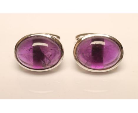 A PAIR OF CUFFLINKS, the oval cabochon polished amethysts in a plain white collar with swivel fastener (Est. plus 21% premium