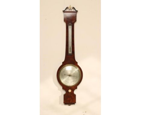 A MAHOGANY WHEEL BAROMETER signed Elliot Bros., The Strand, London, with thermometer and silvered dial, the case with scrolle