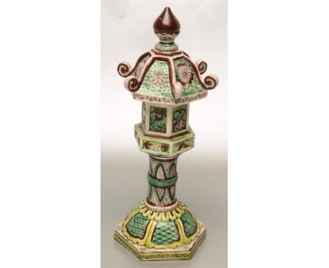 AN EARTHENWARE KANGXI STYLE STAND AND COVER painted in green, yellow and brown with stylised panels, the lift-off cover with 