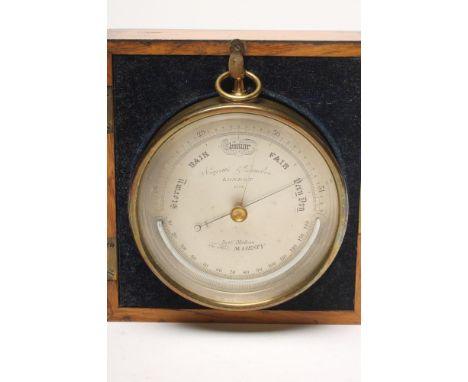A BRASS CASED ANEROID BAROMETER by Negretti &amp; Zambra, London, the silvered dial with semi-circular thermometer, in origin