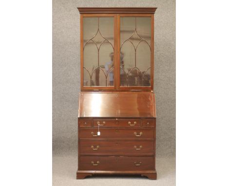 A GEORGIAN MAHOGANY BUREAU BOOKCASE, mid/late 18th century, the moulded cornice over two Gothic astragal glazed doors enclosi