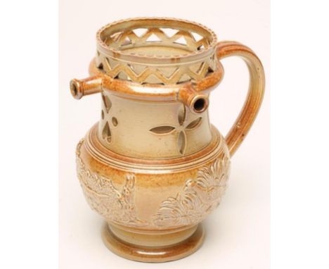 A SALTGLAZE STONEWARE PUZZLE JUG, early 19th century, of typical form with pulled and applied handle, zig-zag pierced rim wit