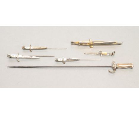 SIX SWEETHEART MINIATURE BAYONETS, 1915-1926, comprising three Belgian lapel pins and one pendant with inscribed blades and m