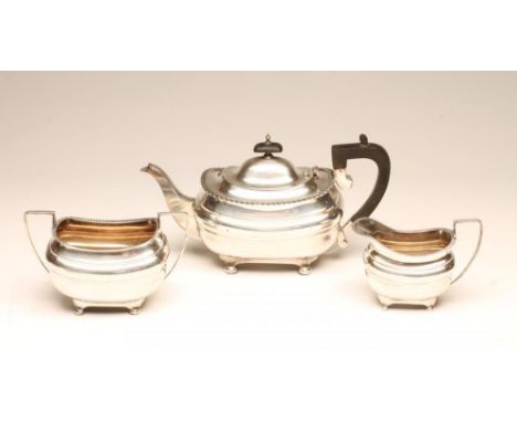 A SILVER THREE PIECE TEA SERVICE, maker Walker &amp; Hall, Sheffield 1915, of rounded oblong form with applied gadrooned rim 