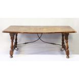 A GOOD SPANISH SLAB TOP RECTANGULAR DINING TABLE on end supports with metal connecting bar. 6ft 5ins