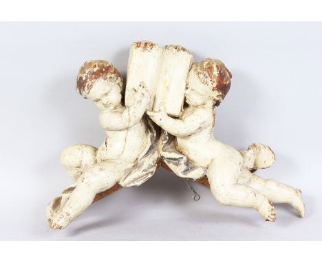 AN 18TH CENTURY ITALIAN CARVED AND PAINTED DOUBLE CUPID BRACKET. 18.5ins long x 10ins high.