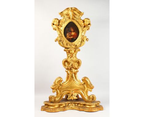 AFTER GUIDO RENI. AN OVAL PORTRAIT in a superb Italian carved wood frame with cupid heads, acanthus and scrolls. 18ins long x