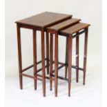 A NEST OF THREE EDWARDIAN MAHOGANY RECTANGULAR TOP TABLES. 1ft 7ins high.