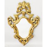 AN ITALIAN CARVED AND GILDED SHAPED MIRROR with scrolls and acanthus. 2ft 9ins long x 1ft 9ins