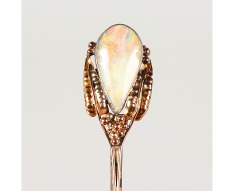 AN ARTS & CRAFTS BROOCH, collet set  with a pear shaped opal, with seed and leaf surround to an elongated pin.