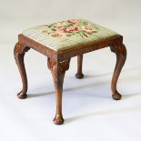 A RECTANGULAR TOP FIGURED WALNUT STOOL with needlework top on cabriole legs, with pad feet. 1ft 8ins