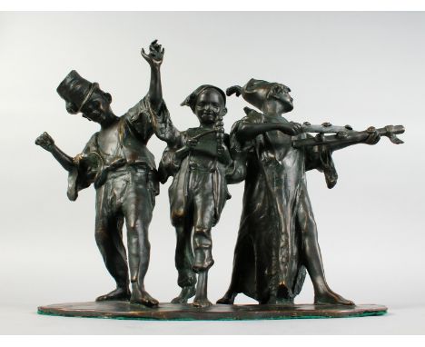 A BRONZE GROUP OF THREE YOUNG MEN DANCING AND MAKING MUSIC. 12ins high x 13ins long.