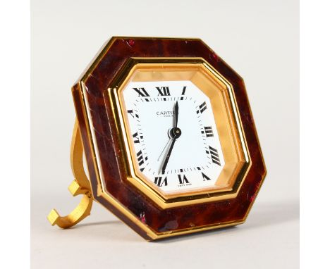A GOOD CARTIER OCTAGONAL CLOCK, in a red Cartier wallet.