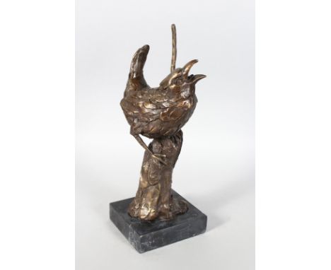 A BRONZE STUDY OF A BIRD ON A BRANCH. On a marble base. 12ins high.