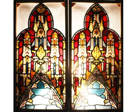 A GOOD PAIR OF 19TH CENTURY STAINED AND PAINTED WINDOW PANELS of pointed arched shape, decorated with architectural and flora