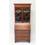 A GEORGIAN STYLE MAHOGANY BUREAU BOOKCASE, glazed doors to the top over a bureau base, on bracket