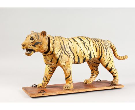 A VICTORIAN AUTOMATON ANIMAL "TIGER" WITH NODDING HEAD, on a wooden base with wheels. 17.5ins long.