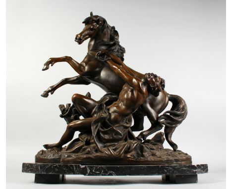 A LARGE BRONZE GROUP OF A YOUNG MAN TRYING TO RESTRAIN A POITEVIN HORSE, standing on a marble base. 21ins high x 20ins long.