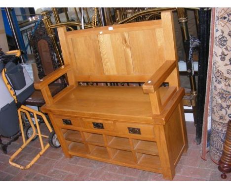 A light oak hall bench with three drawers and shoe compartments below