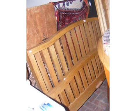 A light oak bed frame with slat back headboard 