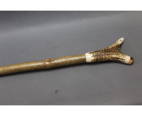 Walking stick with ash shaft and red stag antler handle, with combined whistle.  Length 142 cm. 