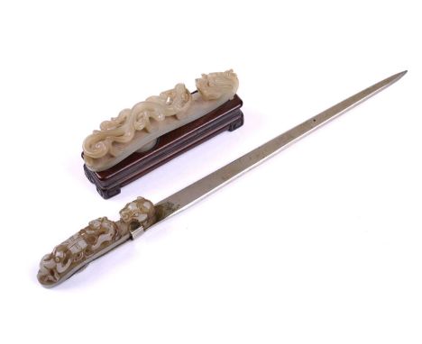 A Chinese carved pale green jade belt hook, carved and pierced with sinuous Chilong and the hook terminal in the form of a Dr