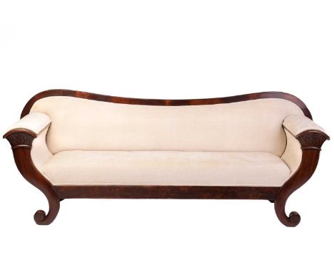 A French Empire early figured mahogany scroll end sofa, the arms carved as a stylized cornucopia and with a concave cross gra