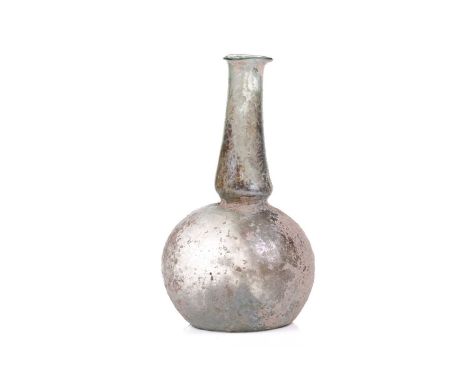 A Roman glass bulbous flask with everted rim, signs of oxidation and encrusted soil to the iridescent surface, bearing an old