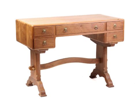 A walnut writing table, probably of the workshops of Arthur Romney Green, C.1925 the five drawers with brass handles, on soli