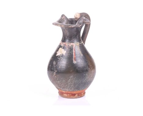 A black painted oinoche (wine ewer), In the Greek Gnathian pottery style, with a rounded, fluted body tapering towards the fo