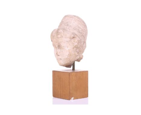 A Marble head of a female, Roman 2nd cenutry and later, depicted in traditional form, with later carving to the top of the ha