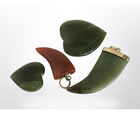 A polished jade claw pendant, length 4cm, similar agate pendant and two jade hearts.