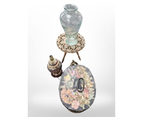 A decorative gilded lamp base, painted decoupage tin hat box, oriental carved wooden table and a glass vase 