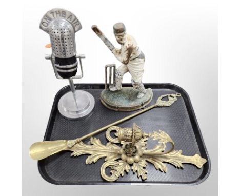 A cast iron painted door stop in the form of a W G Grace, a brass shoe horn, a wall candle sconce and a microphone paperweigh