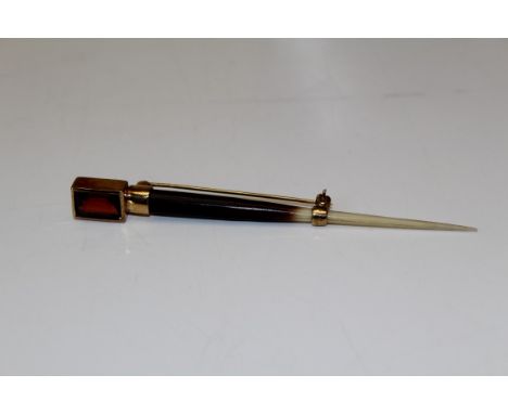 A linear garnet and porcupine spine brooch. Featuring a bezel set octagonal step cut garnet mounted upon a polished porcupine